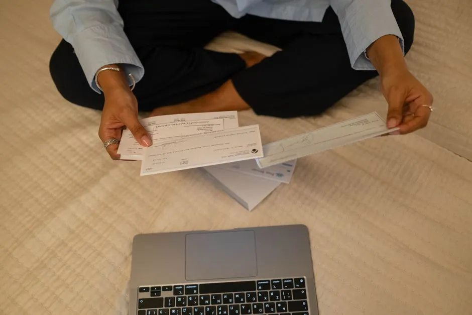 Close-up of a person's hands holding several paper checks